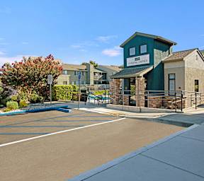 A sunny day at the entrance of a building with a sign that reads  at The Henley Apartments, Suisun City, CA, 94585