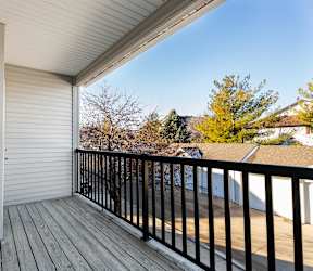 A balcony with a black railing and a grey wall.at Diamond Brooke, Iowa