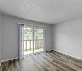 A room with a sliding glass door leading to a balcony.at Fish Creek, Iowa
