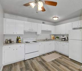 A kitchen with white cabinets and a bar area with stools.at Fish Creek, Iowa