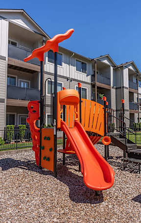 A playground with a slide and a climbing frame in front of a residential building at Timberridge Place Apartment Homes, Albany, 97322