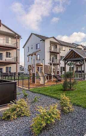A swimming pool in a residential area with a blue chair at Woodburn Place Apartment Homes, Woodburn, OR, 97071