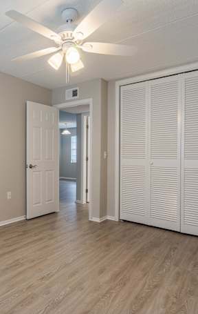 A spacious room with wooden floors and a dining table set up with chairs. at Imperial Gardens Apartments, Clearwater, FL, 33764