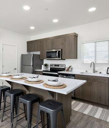 A kitchen with a white countertop and brown cabinets.