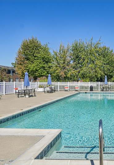 Outdoor pool area with white fence and seating at Southpointe Square Apartments, Woodhaven, MI