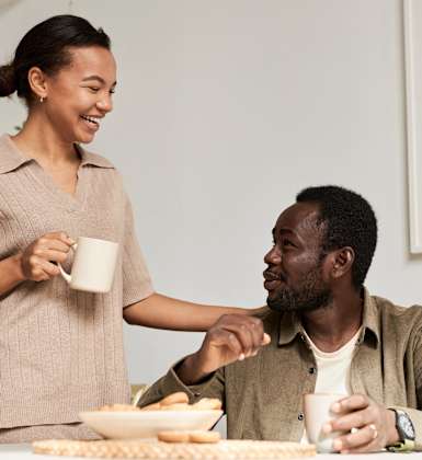 A woman serving a man a snack.