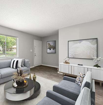 A living room with a grey couch, a coffee table, and a painting on the wall at Northgate Townhomes in Georgia, 30084