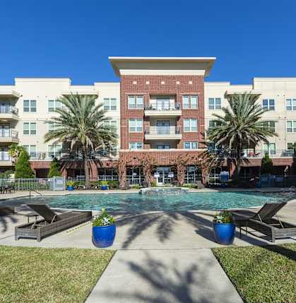 A large apartment complex with a pool in the middle.