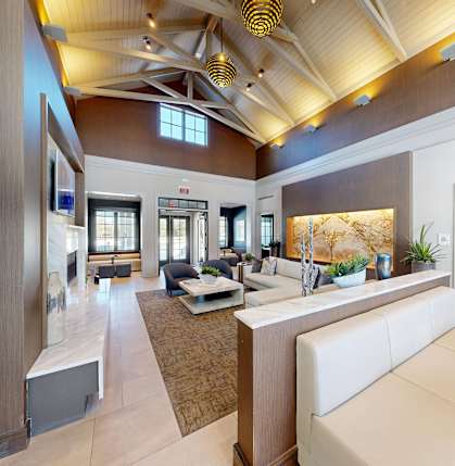 A modern living room with a white sofa and a wooden ceiling.