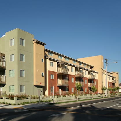 Apartment buildings with balconies line a street.