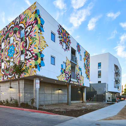 A white building with a colorful mural on the side.