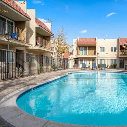 A swimming pool in front of apartment buildings.