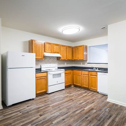 the preserve at ballantyne commons apartment kitchen with white appliances and wooden cabinets at Crescent Pointe, Stafford, Virginia