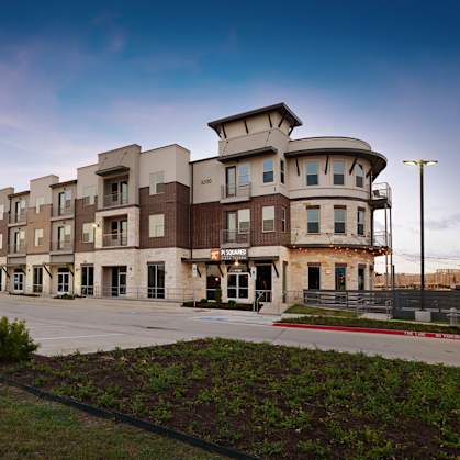 a row of apartment buildings on a city street at Epic Apartments, Denton, TX, 76210