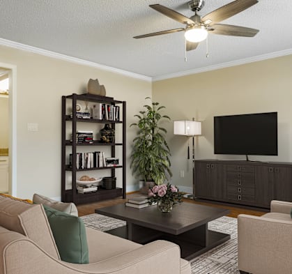 A living room with a beige couch, a black bookshelf, a coffee table, and a flat-screen TV.