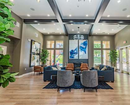 A modern living room with a large blue sofa and a wooden floor.