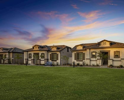 A row of houses with a green lawn in front.