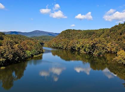 A serene landscape with a lake surrounded by trees in autumn colors.