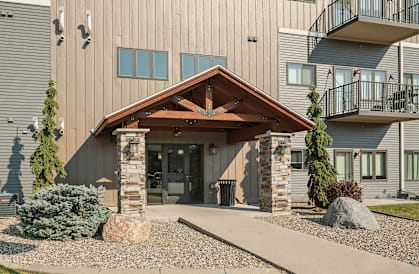 A modern building with a wooden front entrance and a balcony on the second floor.