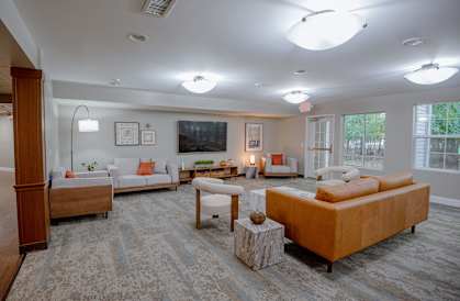 A living room with a white couch and a brown sofa.