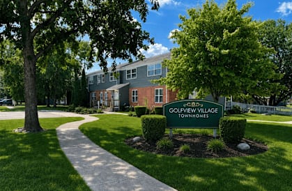 A sign that says Golfview Village Townhomes in front of a building.