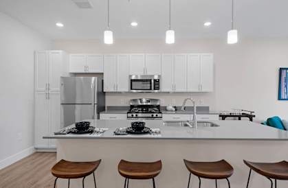 A modern kitchen with white cabinets and a center island.