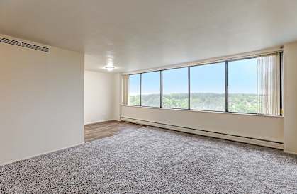 A room with a large window overlooking a landscape.