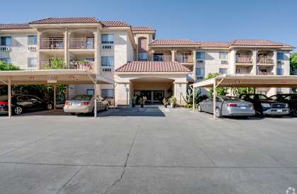 an empty parking lot in front of an apartment building with cars parked at Flamingo Garden Senior Apts, El Monte, 91732