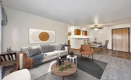 A living room with a grey couch and a brown chair. at Somerset Apartments, Des Moines, IA, 50315