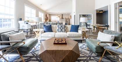 A modern living room with a white sofa, a wooden coffee table, and a chandelier.