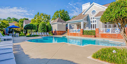 A house with a pool in front of it.
