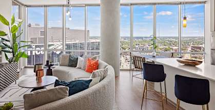 A living room with a large window overlooking a cityscape.