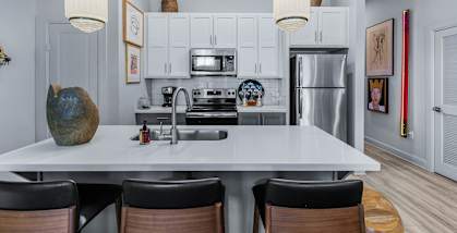A modern kitchen with a large island and stainless steel appliances. at The Quarter Lofts Apartments, Mississippi, 39216