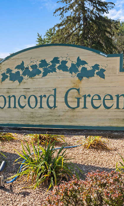 a sign for concord green in front of a park