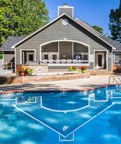 a swimming pool in front of a house with a pool