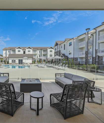 an outdoor patio with chairs and tables next to a pool