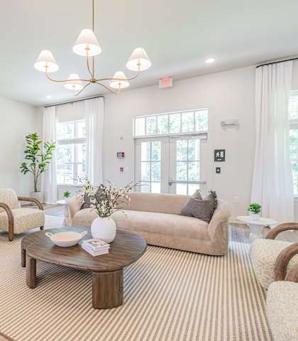 A living room with a large couch, a coffee table, and a television.