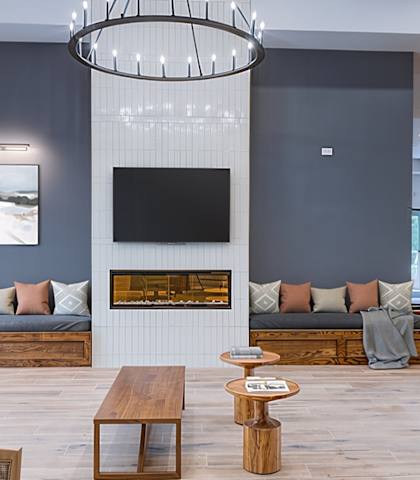 A modern living room with a fireplace and a large painting on the wall.
