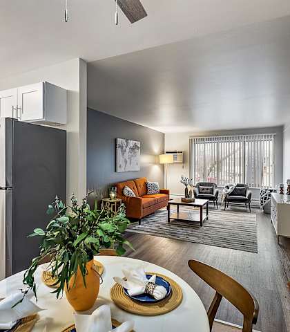 a kitchen and living room with a refrigerator and a table at Town & Country Apartments - Wixom, MI, Michigan
