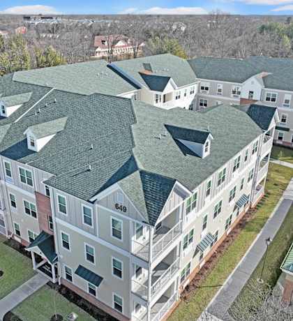 an aerial view of an apartment building with green roofs at The Franklin at Hillsborough Apartments, Des Moines