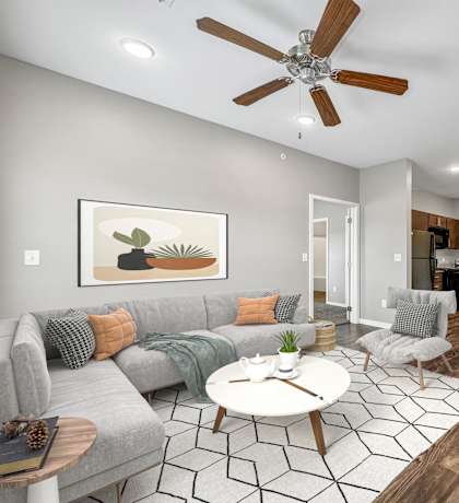 A living room with a grey couch and a coffee table at The Barclay Apartments, Altoona, IA, 50009