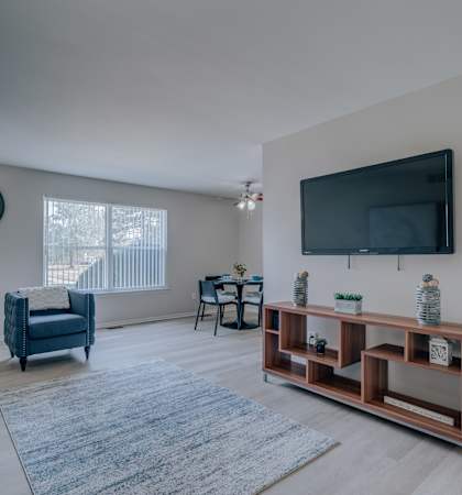 A living room with a blue couch and a wooden shelf.