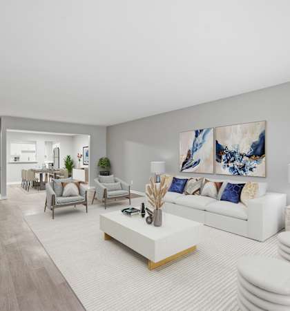 A modern living room with a white sofa and a large painting on the wall.