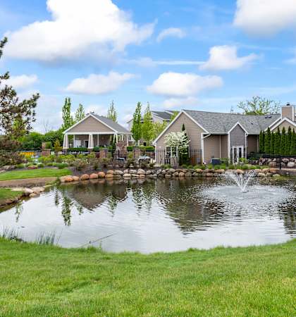 A house with a pond in front of it.