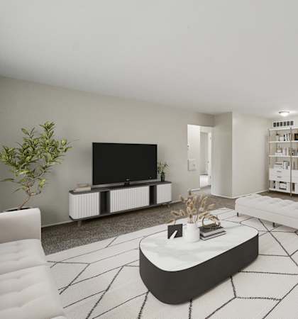 A modern living room with a white sofa, a black coffee table, and a flat-screen TV.