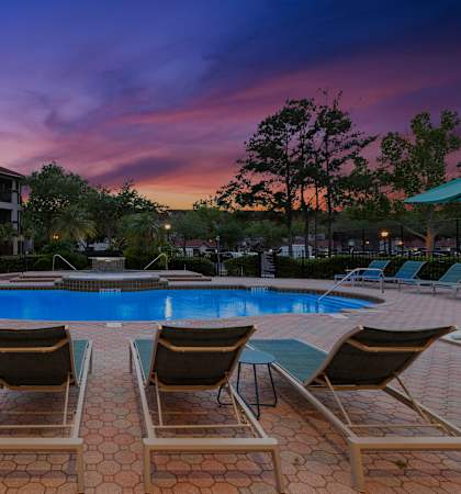 Resort-style swimming pool at twilight - Egret's Landing Apartments