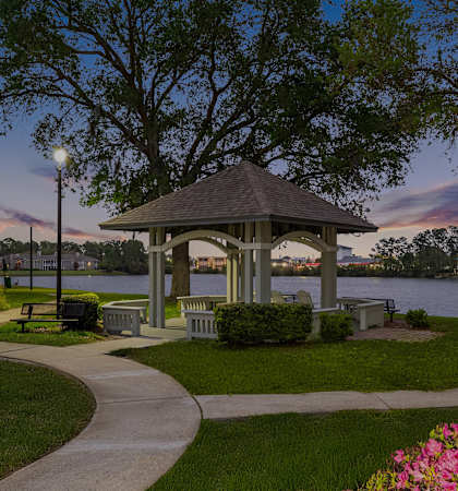 Lakeside gazebo with fire pit and seating area - The Colony at Deerwood Apartments
