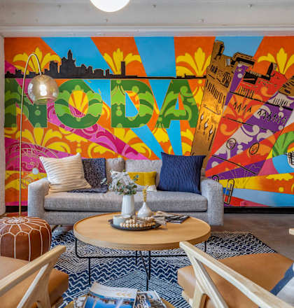 a living room with a colorful mural on the wall at Highland Mill Lofts in NC 28205