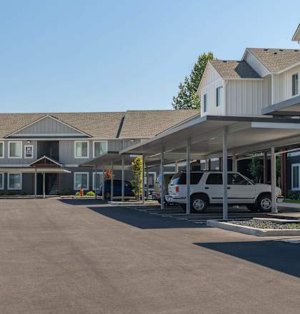 A parking lot with cars and a building in the background at Cascade Place Apartment Homes, Molalla, OR, 97038
