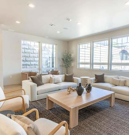 A living room with a white couch, a wooden coffee table, and a chair at Westgate Apartment Homes, Pendleton, OR, 97801